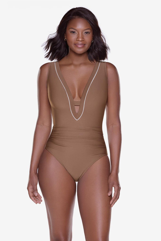 Woman wearing a brown one-piece swimsuit with a deep v-neckline