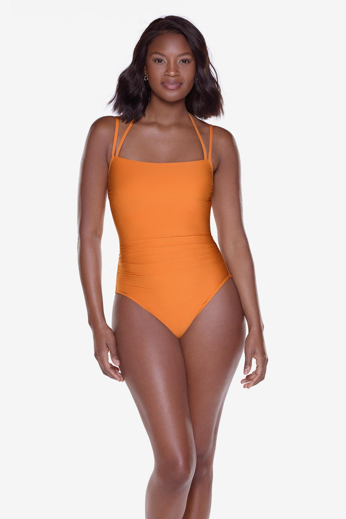 Woman wearing a bright orange one-piece swimsuit with double straps
