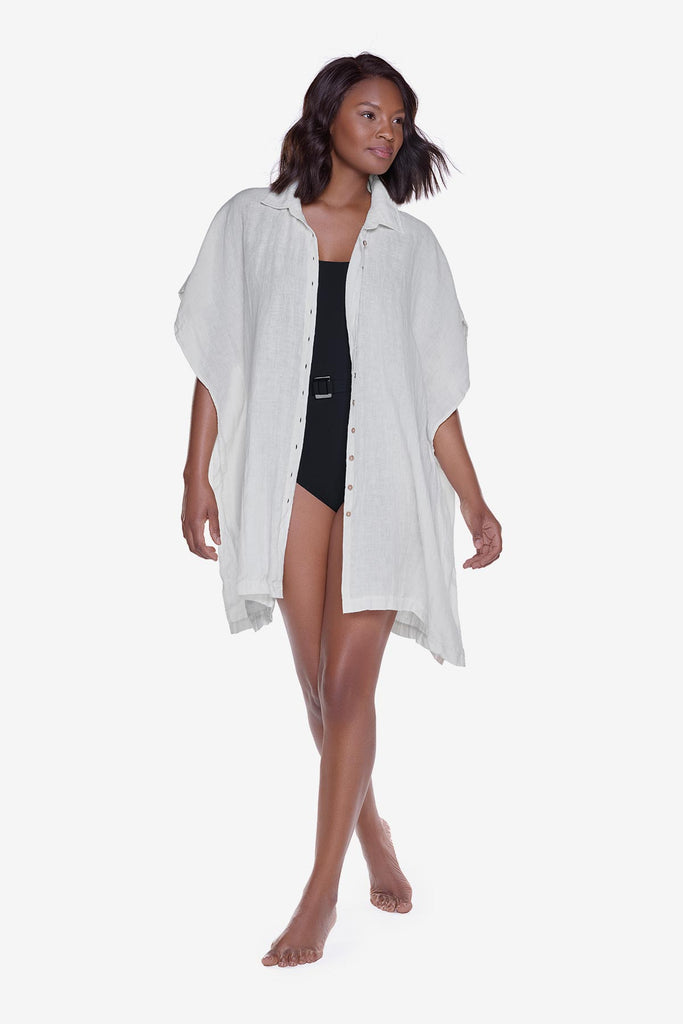Woman wearing an ivory-colored oversized beach shirt