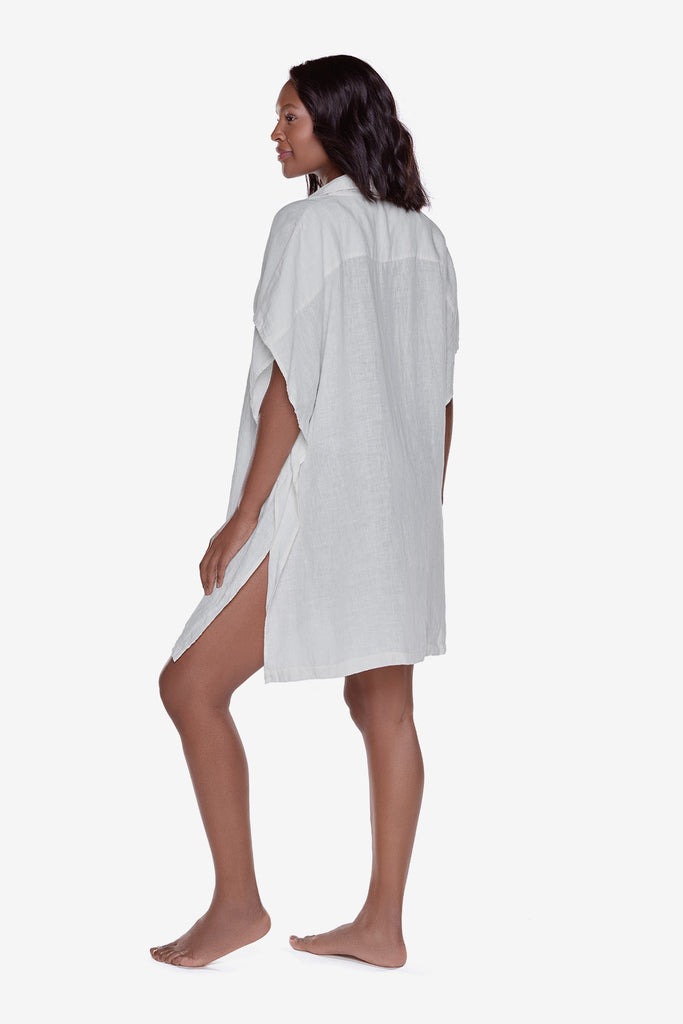 Woman turned left wearing an ivory-colored oversized beach shirt