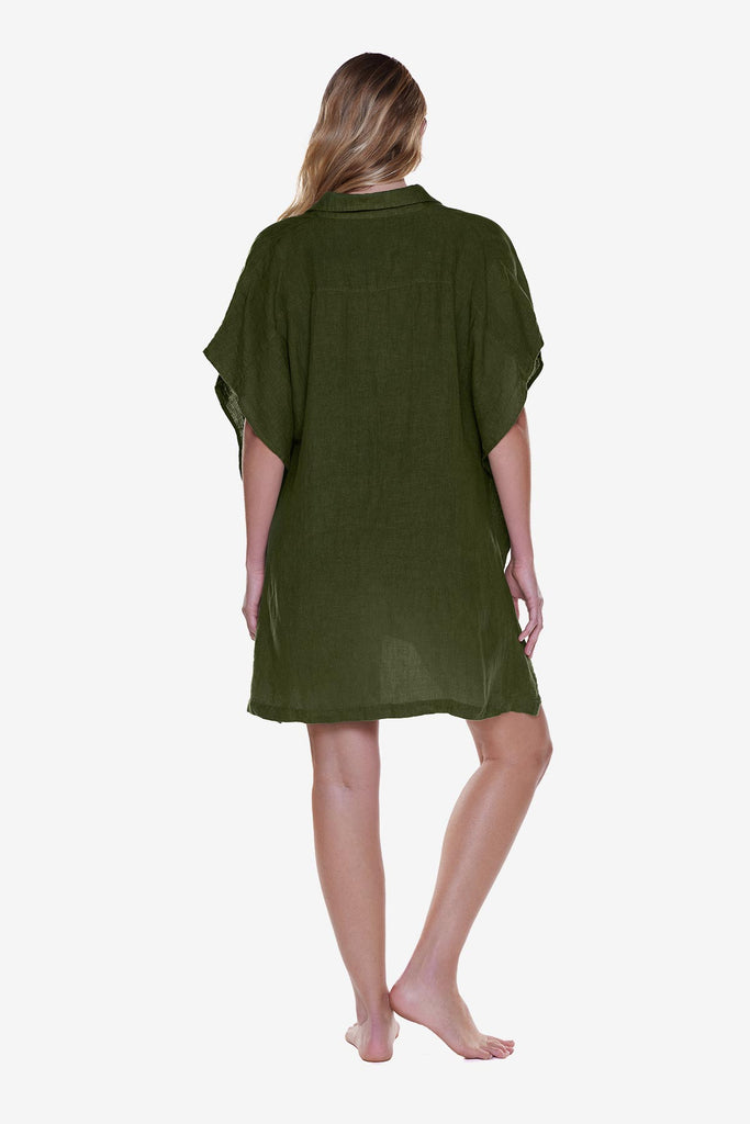 Woman faced away wearing a dark green oversized swim shirt cover up
