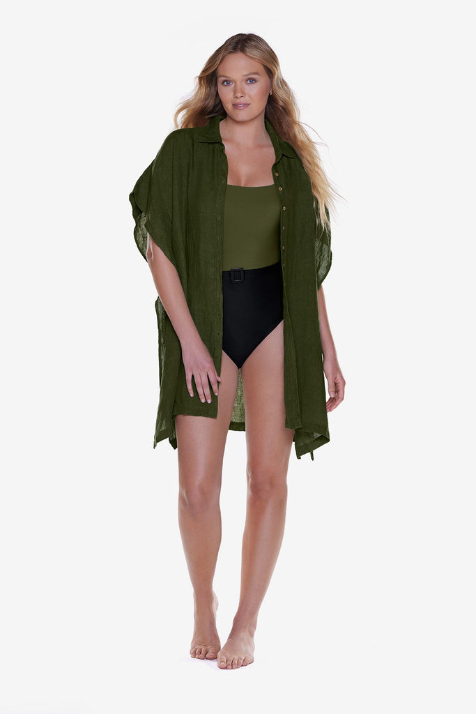 Woman wearing a dark green oversized swim shirt cover up