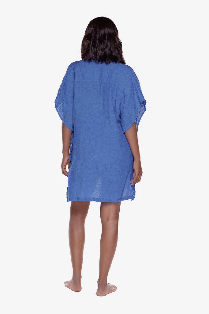Woman turned away wearing a blue oversized swim cover up