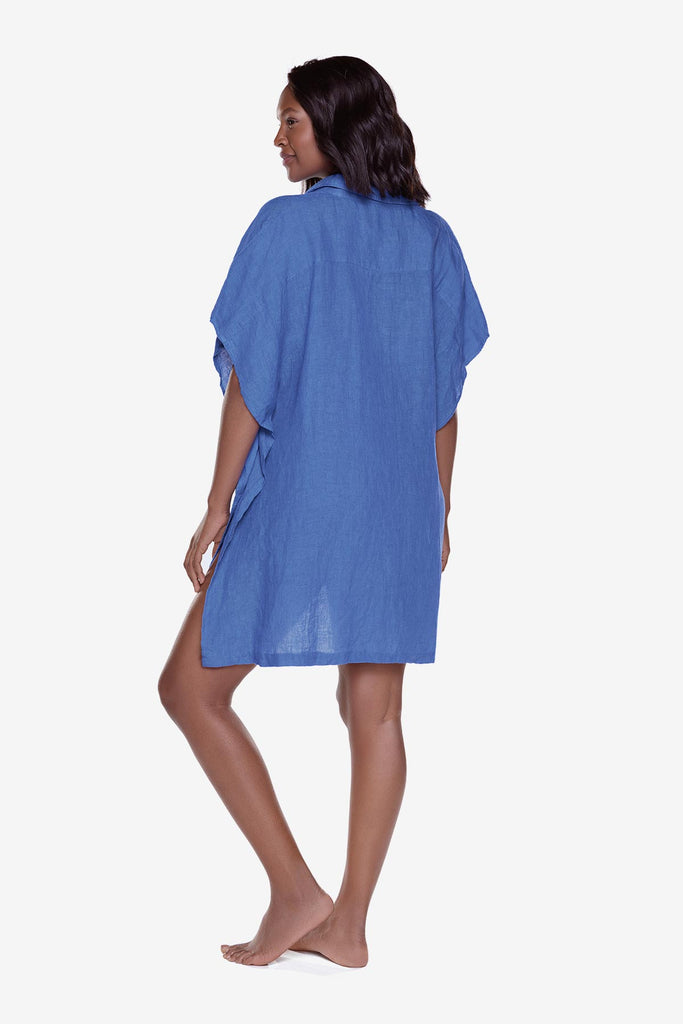Woman turned left wearing a blue oversized swim cover up