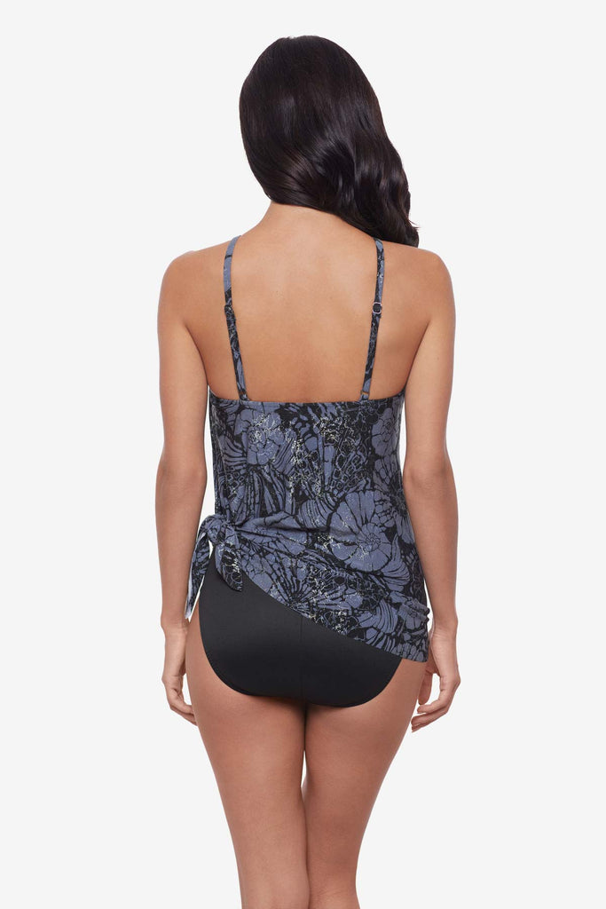 Woman turned away wearing a shimmery blue and black floral tankini top