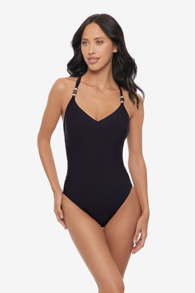 Woman wearing a black one-piece swimsuit with beads on the straps