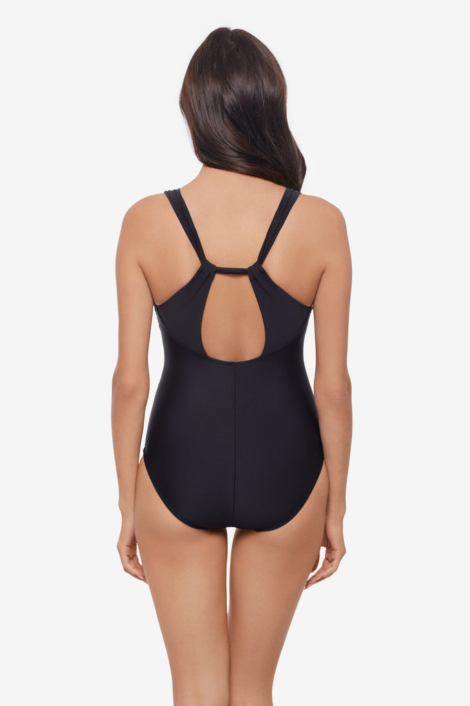 Woman wearing a black one-piece swimsuit with an X back