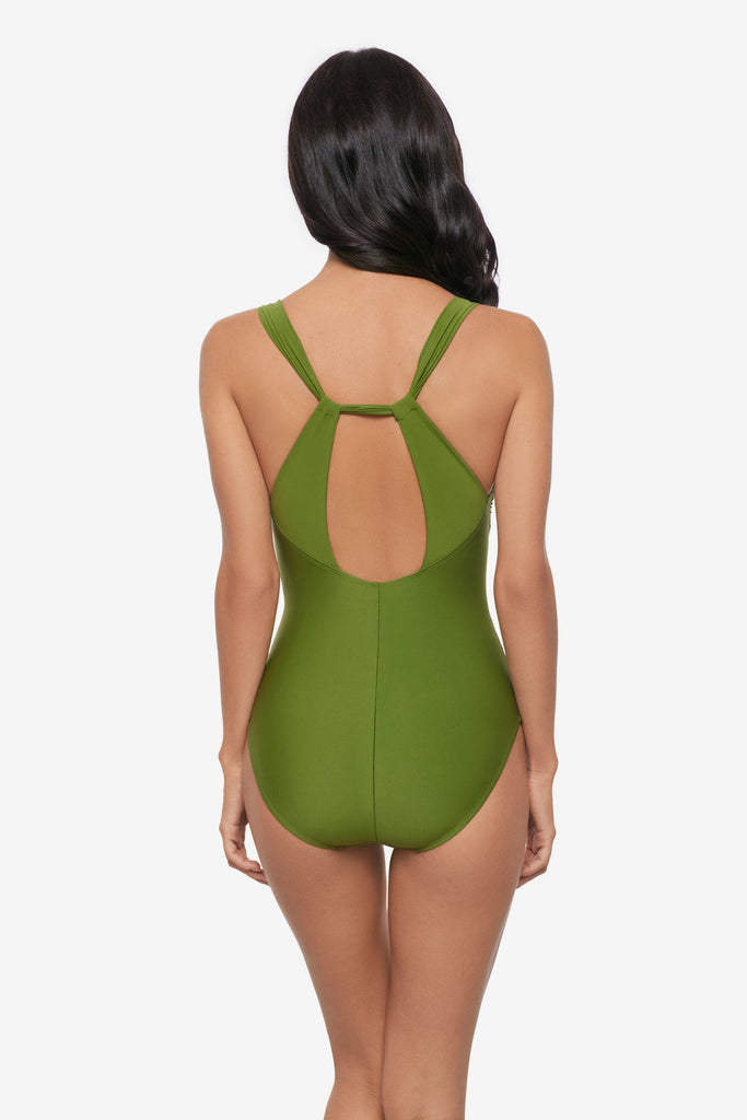 Woman turned away wearing a green one-piece swimsuit with an X back