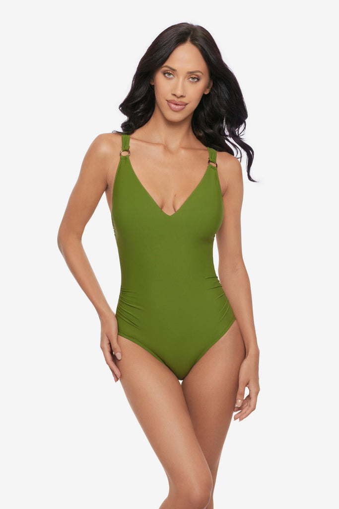 Woman wearing a green one-piece swimsuit with O rings on the straps