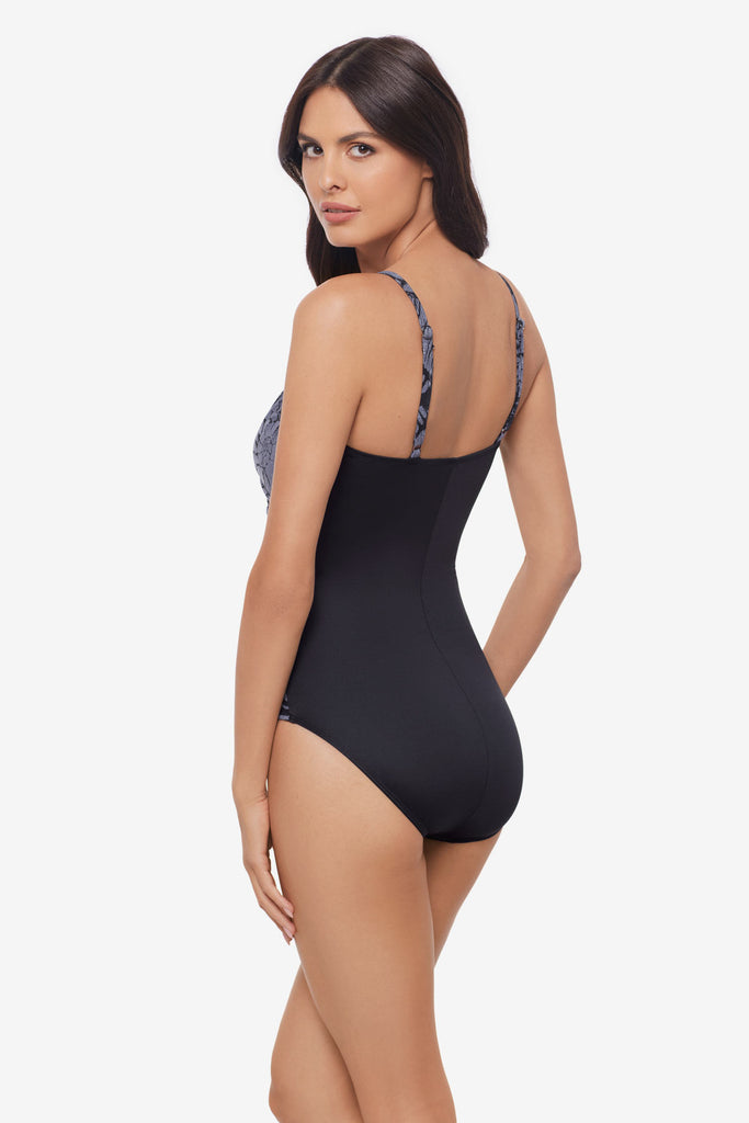 Woman turned left wearing a shimmery one-piece swimsuit 