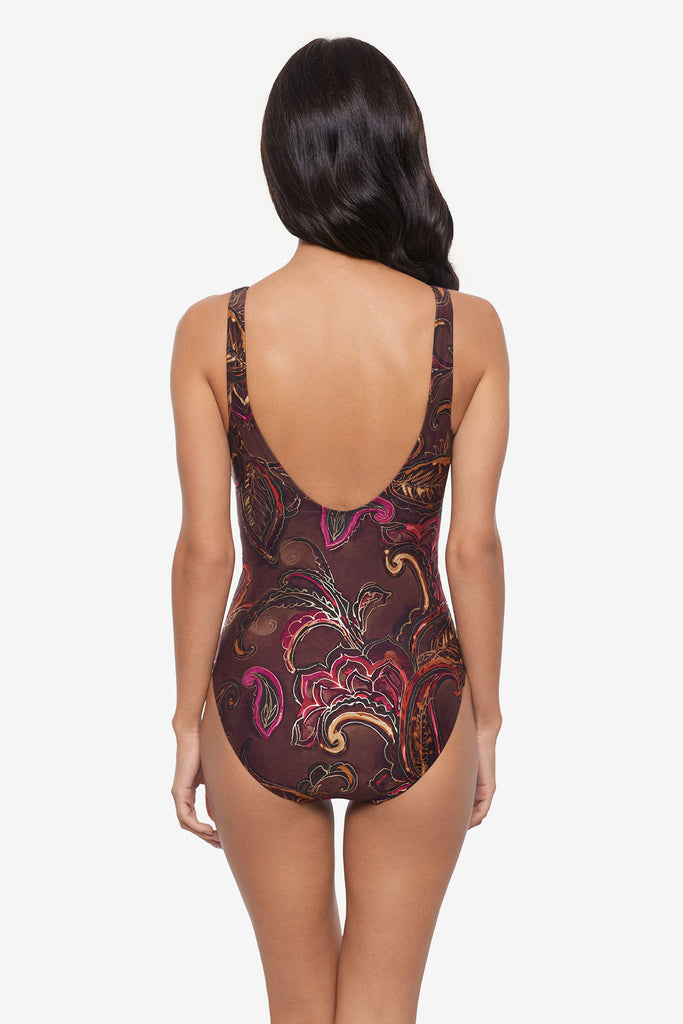 Woman turned away wearing a multicolored paisley printed one-piece swimsuit