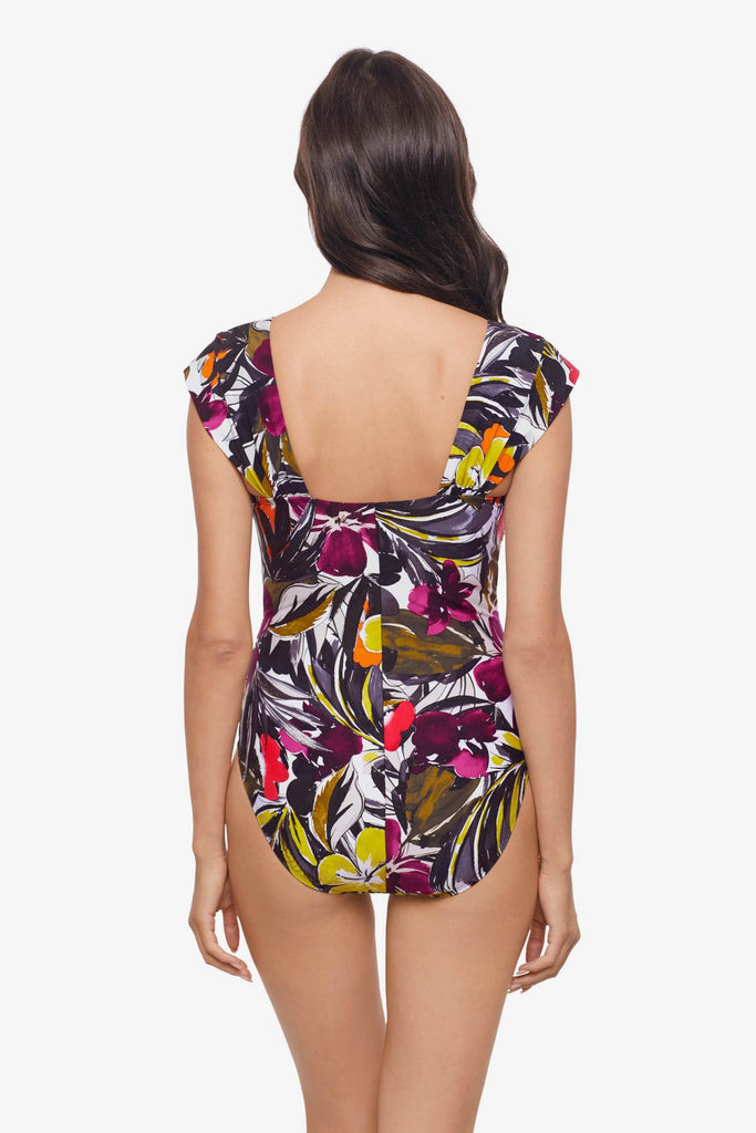 Woman turned away wearing a one-piece swimsuit with a multicolored floral print