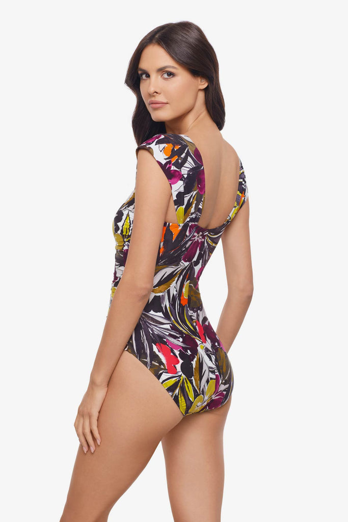 Woman turned left wearing a one-piece swimsuit with a multicolored floral print