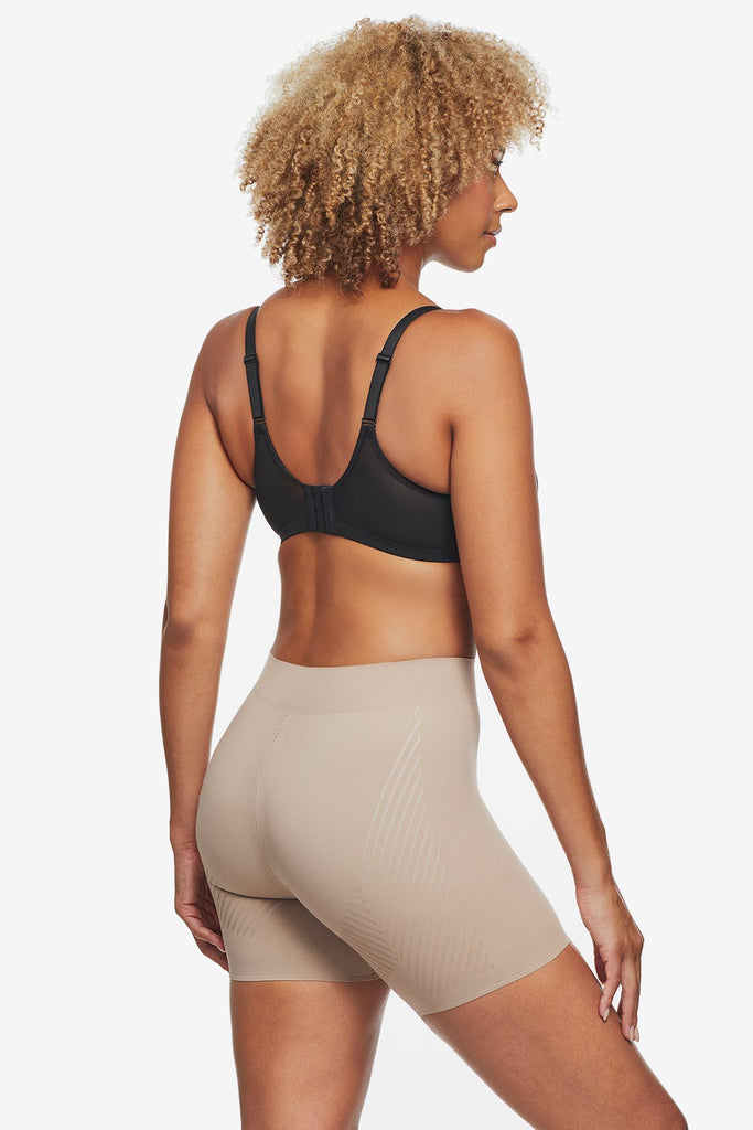 Woman faced away wearing tan bike short shapewear
