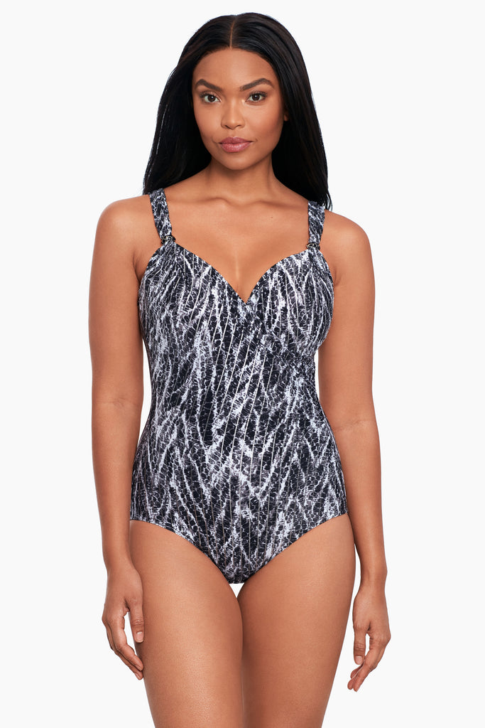 A slim woman wearing a one piece swim dress.
